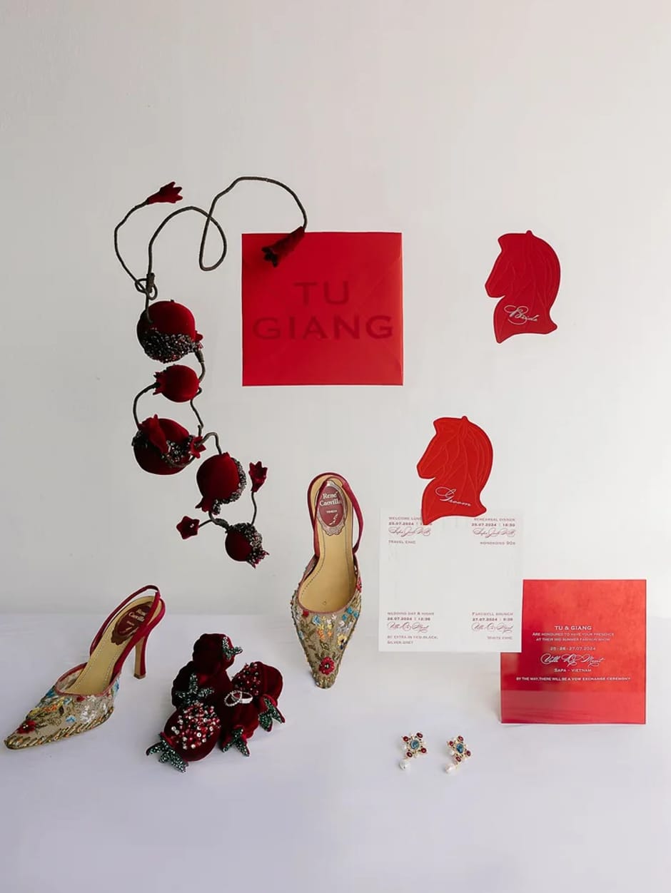 Flat lay of custom wedding invitation suite with red accents