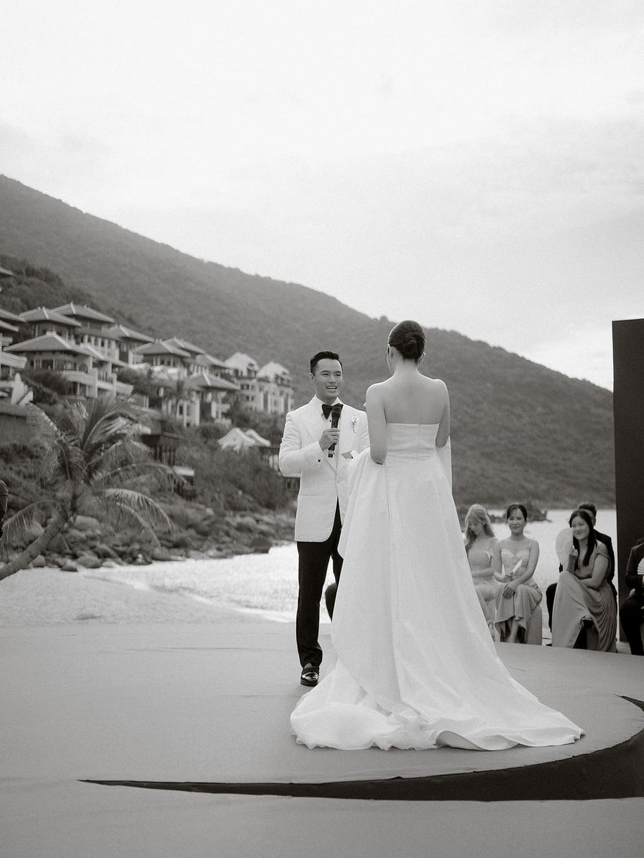 Bride and groom smiling on a coastal hillside wedding stage