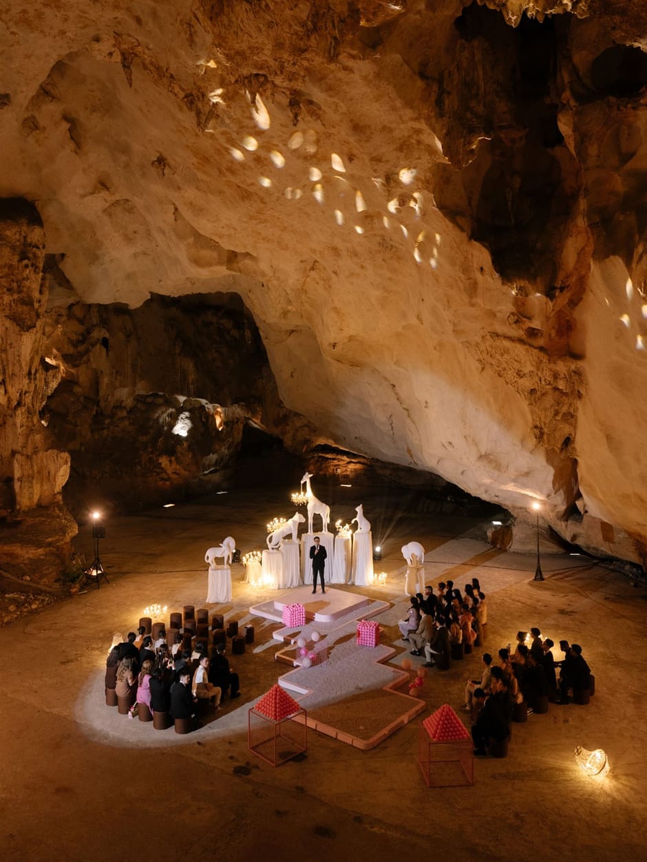 Guests seated for a candlelit cave wedding ceremony with sculptural centerpieces